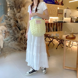 Detailed shot of quilted heart pattern handbag with pink strap in a cafe setting