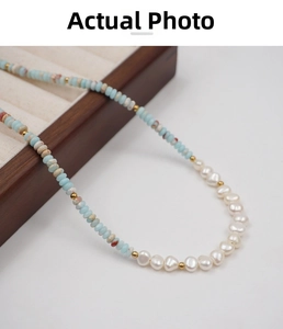 Detailed macro view of colorful natural stone beads and baroque freshwater pearls on a tray