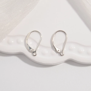 S925 sterling silver D-shaped hoop earring hooks on a textured white ceramic plate