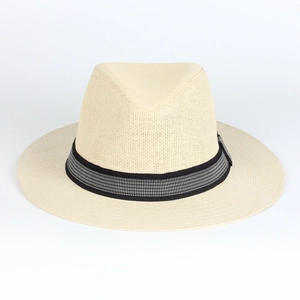 Dettaglio di un cappello di paglia beige con fascia a motivi geometrici bianchi e neri