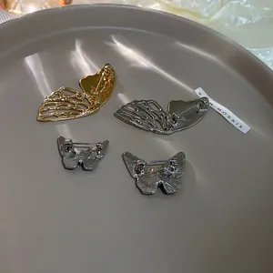 Detailed back view of metal butterfly brooches showing pin mechanism and hollow structure