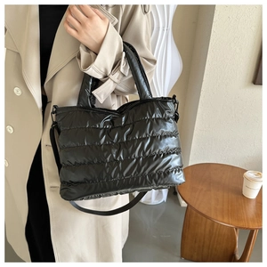 Dettaglio della borsa tote imbottita nera con texture trapuntata e spallacci comodi