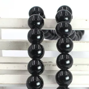 Close-up of polished black agate round beads showing smooth surface and high gloss finish