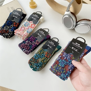 Detail of five pairs of cotton socks with colorful floral embroidery in various colors