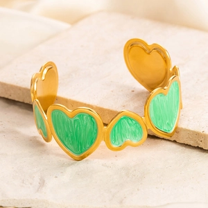 Detail of green enamel heart pattern on a 18K gold-plated stainless steel open bangle
