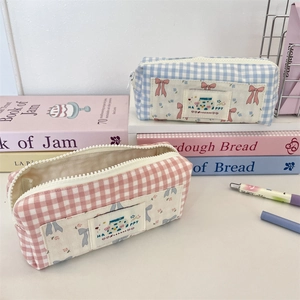 Close-up of pink and blue plaid canvas pencil bags with cute bow and HAPPY embroidery