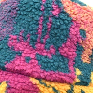 Gros plan sur la texture du polaire sherpa tie-dye d'un chapeau bob multicolore