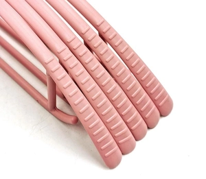 Detail of pink plastic hangers with wide-shoulder non-slip texture and curved design