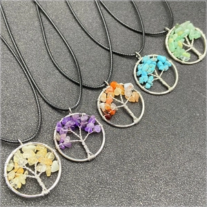 Detail of five colorful tree of life pendants with natural crystals and silver wire wrap