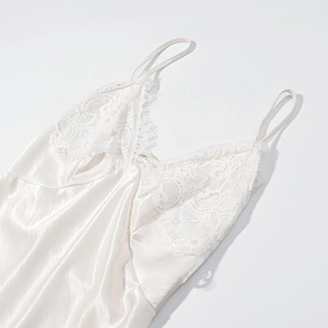 Detailed view of white satin slip dress featuring delicate lace stitching on the bodice