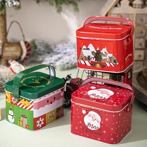 Detail of Christmas tin gift boxes with handles, featuring festive patterns and Merry Christmas text