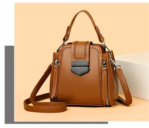 Detail of soft brown leather texture and black metallic clasp on a stylish handbag