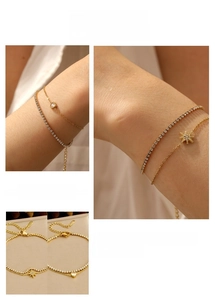 Close-up of double-layer gold stainless steel bracelet with sparkling heart star charms