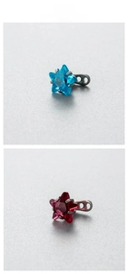 Detail of 6mm star-shaped zircon dermal anchor tops in blue and dark red crystal