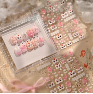 Detail of pink lion dance nail art stickers and gradient press-on nails with pearls