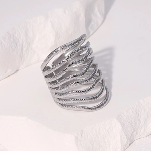 Macro detail of silver multi-layer wavy ring with hammered texture on white background