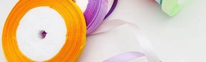 Detail of 1cm colorful satin ribbons in yellow, purple and green for gift packaging