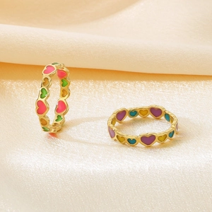 Detailed macro view of colorful enamel heart patterns on gold stainless steel rings