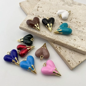 Macro view of colorful heart-shaped enamel pendants with elegant golden alloy edges