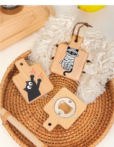 Detailed view of cat-patterned wood bottle openers and fridge magnets on tray