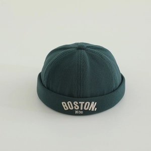Dettaglio del cappello docker in maglia a coste verde scuro con ricamo BOSTON