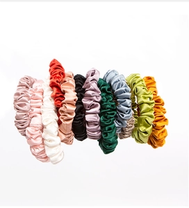 Close-up of 12 multi-colored 22mm mulberry silk scrunchies with a smooth satin texture