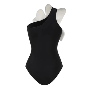 Detail of 3D geometric white butterfly applique on a black one-shoulder swimsuit