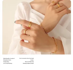 Detail of 18K gold plated titanium steel chain bracelet and geometric rings on model