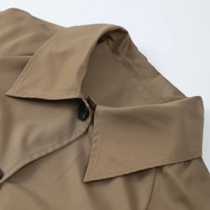 Detailansicht des Khaki-Trenchcoat-Revers mit schwarzen Harzknöpfen und feinen Nähten