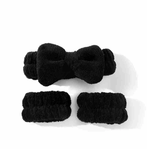 Close-up of black plush coral fleece bow headband and matching wrist wash bands set