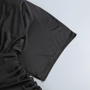 Dettaglio del polsino cucito e della texture arricciata di questo mini abito nero da sera