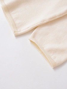 Detailed close-up of cream wool blend knit sweater cuff with ribbed edge texture