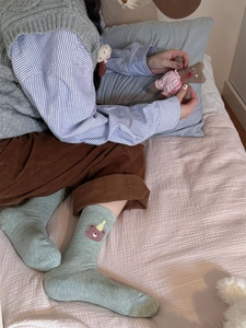Detailed bear embroidery on light green cotton blend crew socks with cozy textures