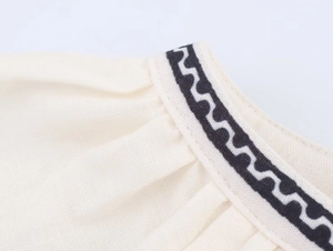 Macro view of cotton linen shirt detail with black geometric wavy lace trim edges
