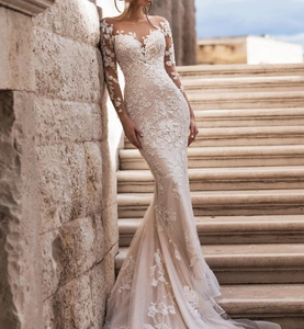 Detailed view of white long sleeve mermaid wedding dress with floral lace appliques