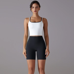 Close-up of white sports top with contrast straps and black high-waisted shorts set