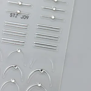 Vue macro de stickers d'ongles 5D gaufrés avec lignes argentées et strass brillants