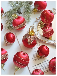 Detail einer roten Satin-Weihnachtskugel mit goldenen Pailletten und Glitzerstreifen