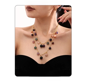 Close-up of a model wearing double-layered gold chains with colorful natural stone beads