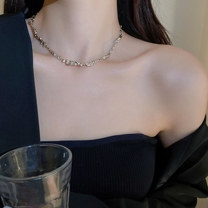 Dettaglio della collana girocollo argento con texture lavica su una modella