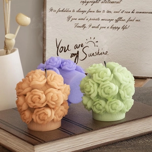 Detailed close-up of rose bouquet scented candles in orange, purple, and light green colors