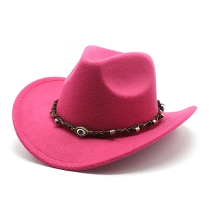 Detail of rose pink felt cowboy hat featuring woven band and evil eye bead ornament