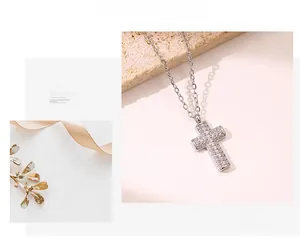 Detailed macro view of cross pendant necklace with micro-pave crystals on stone background