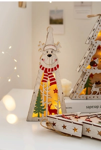 Close-up of wooden Christmas light box with reindeer and tree, warm LED glow