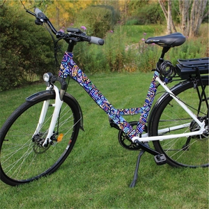 Detail of an electric bike frame featuring colorful neon geometric pattern stickers on grass