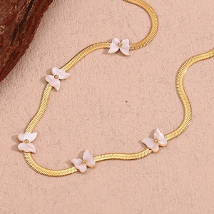 Detailed close-up of 18K gold-plated blade chain necklace with five white shell butterflies
