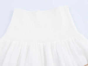 Detailed view of the white smocked elastic fabric on this elegant beach maxi set