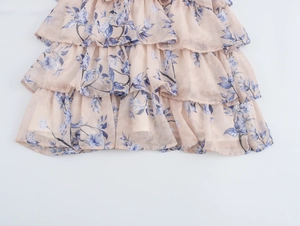 Détail de la jupe rose à volants en mousseline avec imprimé floral de feuilles bleues
