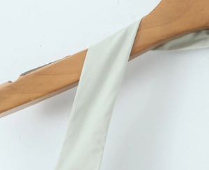 Gros plan sur la sangle licou vert menthe sur un cintre en bois avec texture de tissu