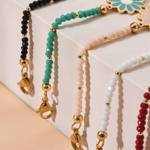 Detailed close-up of colorful enamel daisy charms and faceted beads on stainless steel chains